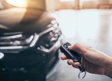 Hand presses unlock on the car remote control. Hand presses unlock on the car remote control.